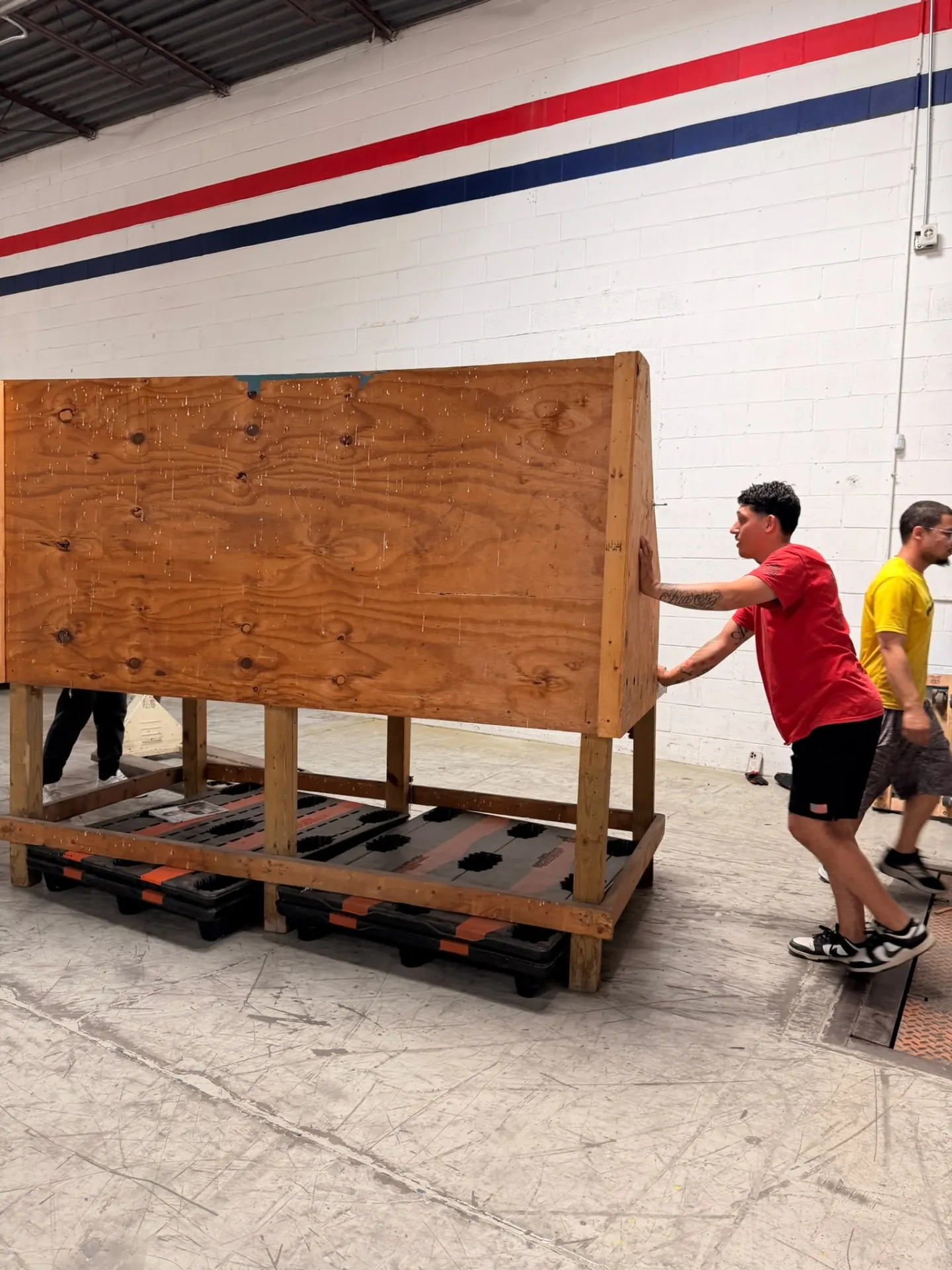 Yellow Truck Moving crew member positioning a wood-crated piece on protective skids